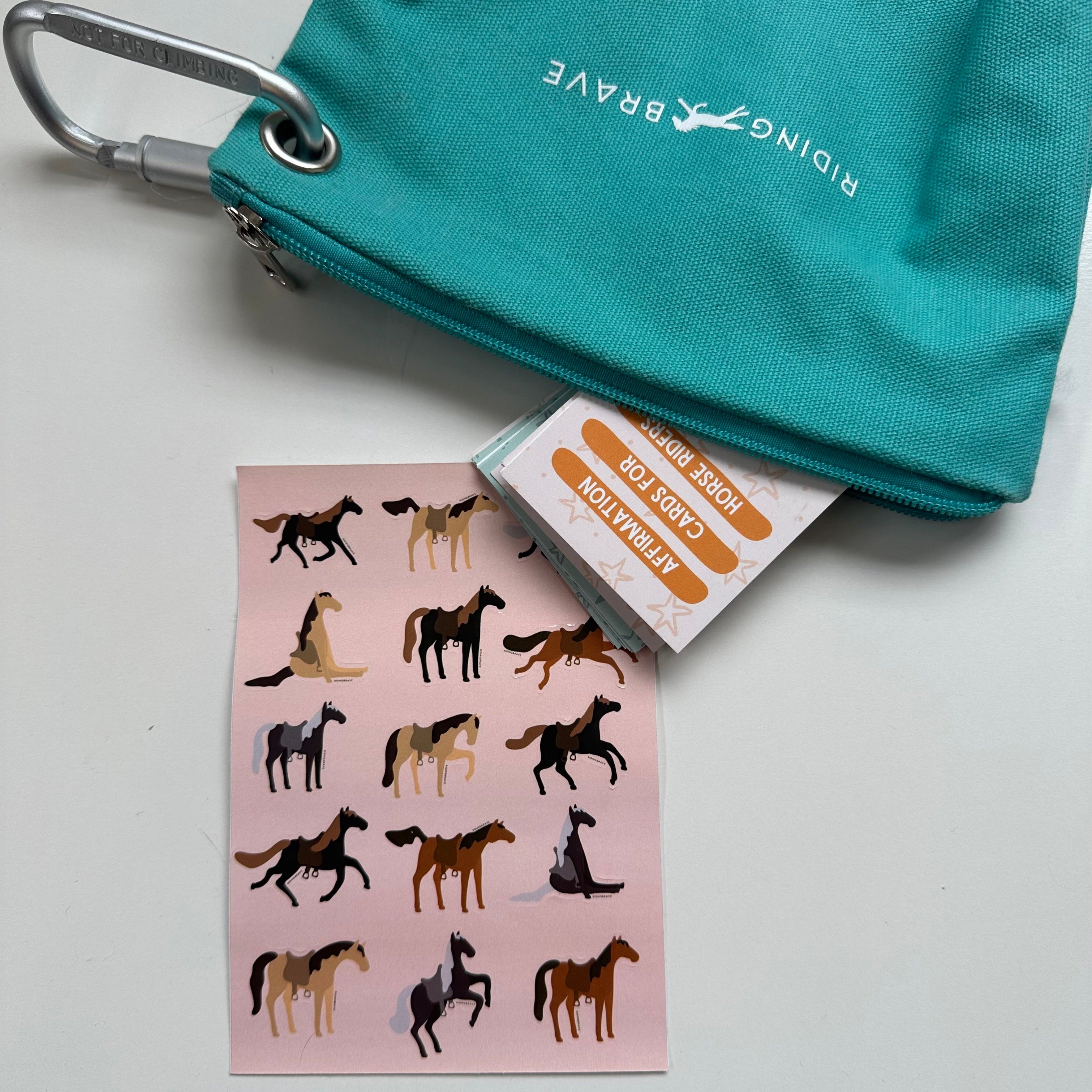 Teal pouch with a carabiner, horse stickers, and a card on a white background