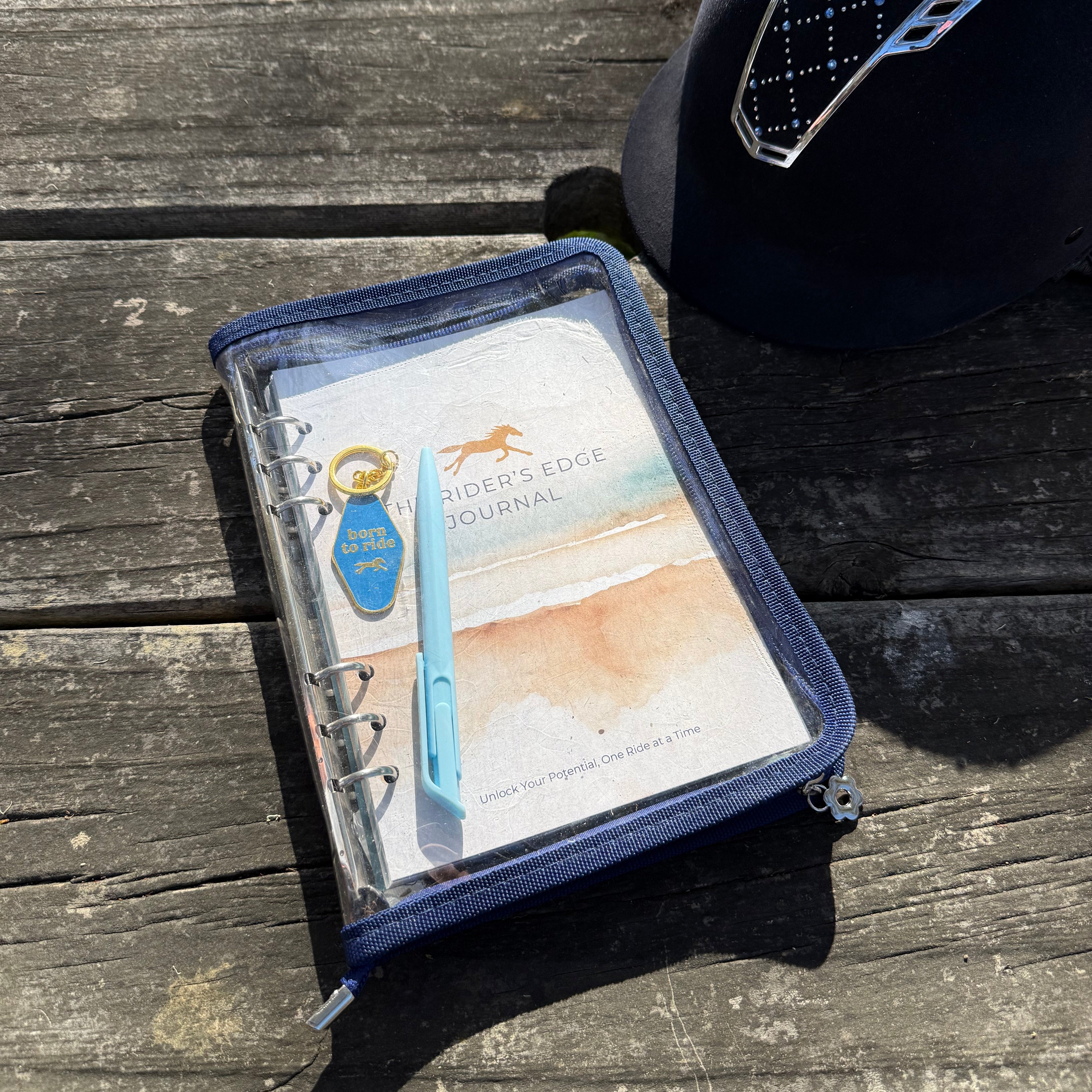Equestrian journal on a wooden bench with a helmet in the background